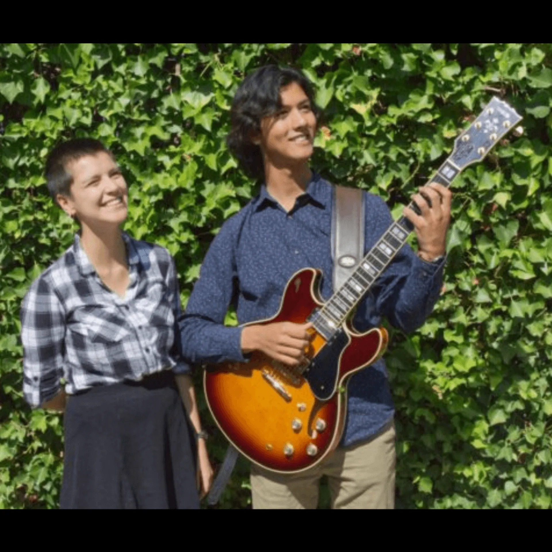 Two musicians, one of whom plays guitar