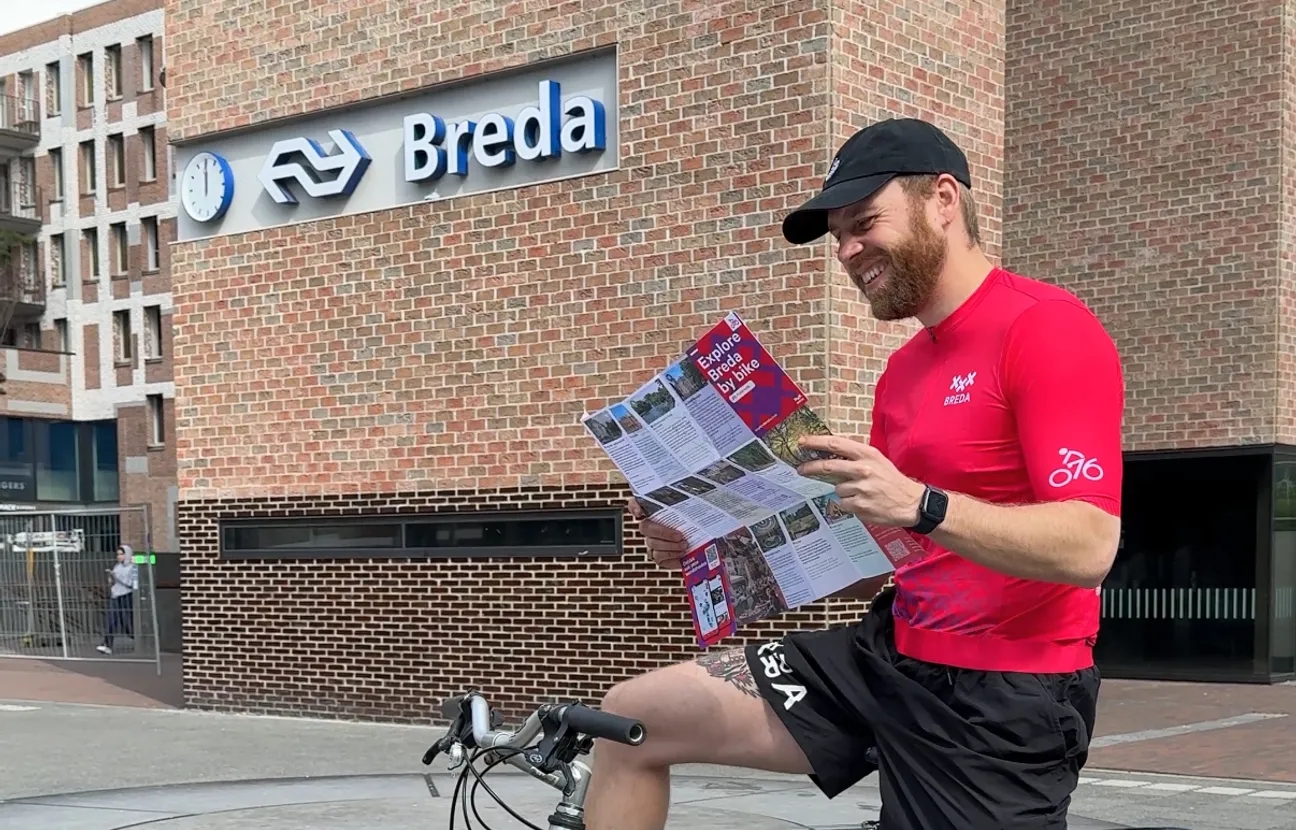 Man op fiets met Bredaas wielershirt en fietskaart