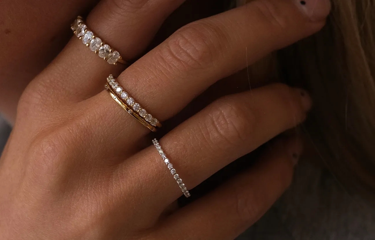 hand met 4 ringen van MiJu in het goud met edelstenen