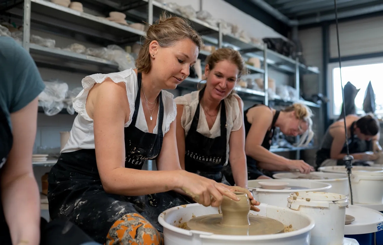 Twee dames aan het werk aan een pottenbakkersschijf