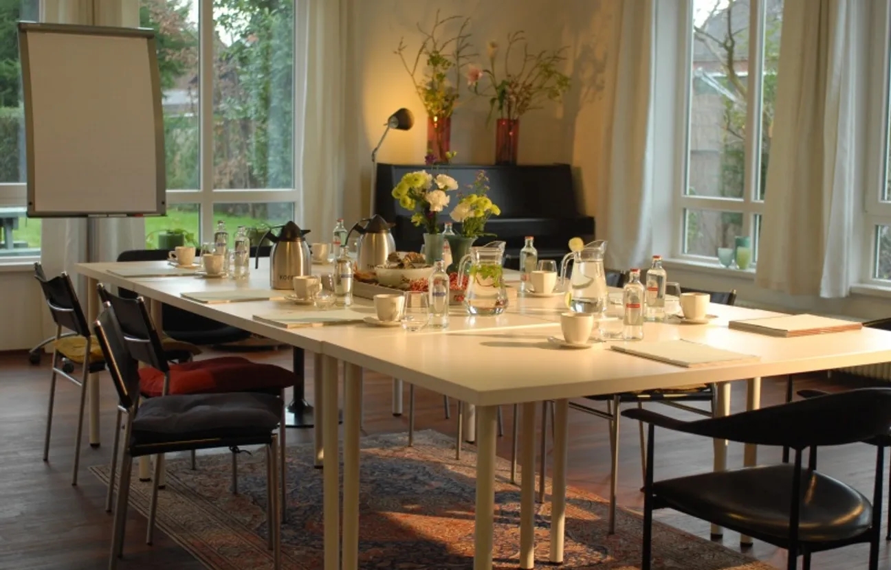 Vergaderzaal DeRuimte met tafel, stoelen en flipover