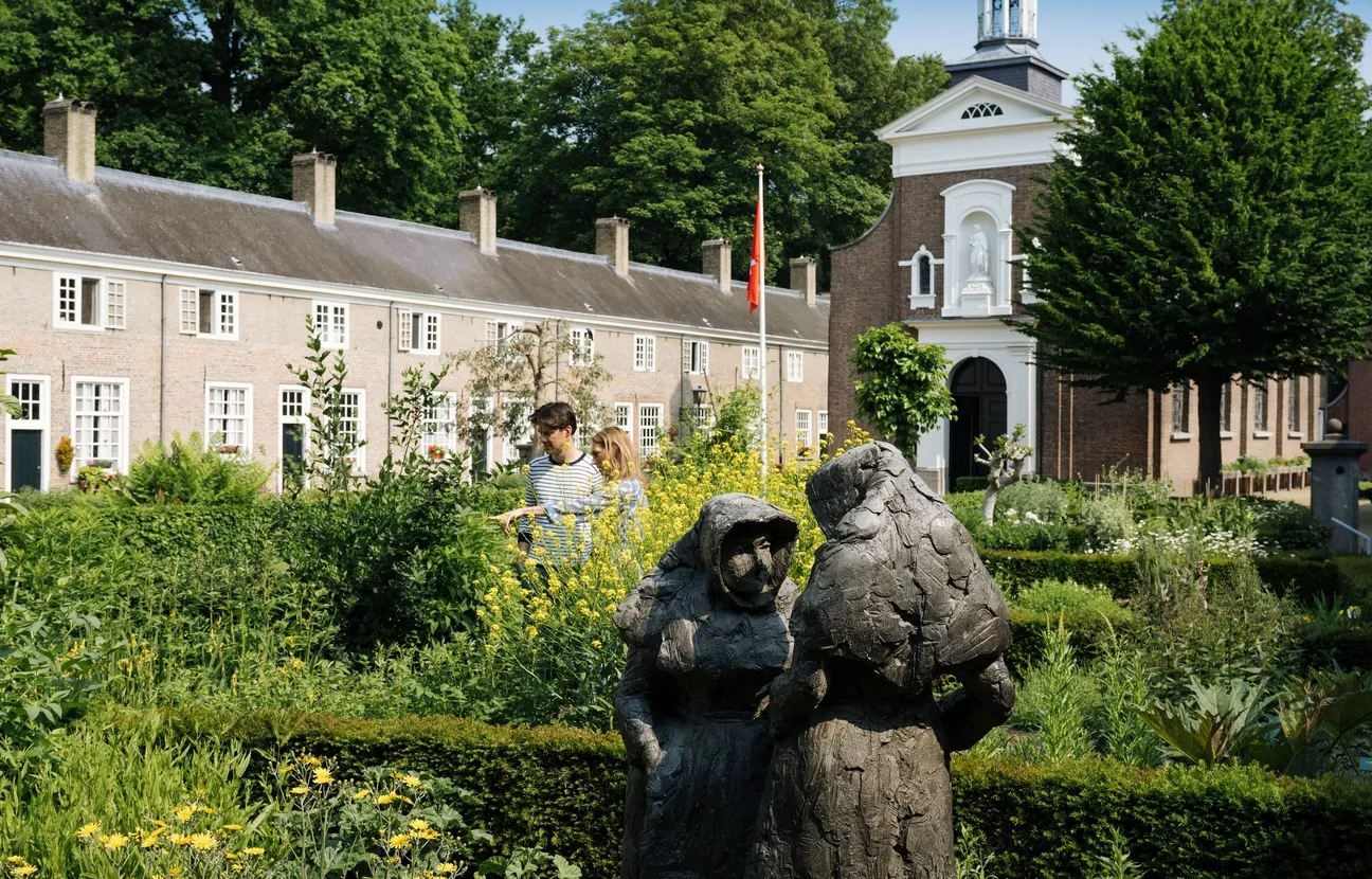 Het groene Begijnhof, met een beeld van twee begijnen, de moestuin, begijnhuizen en de St. Catharinakapel