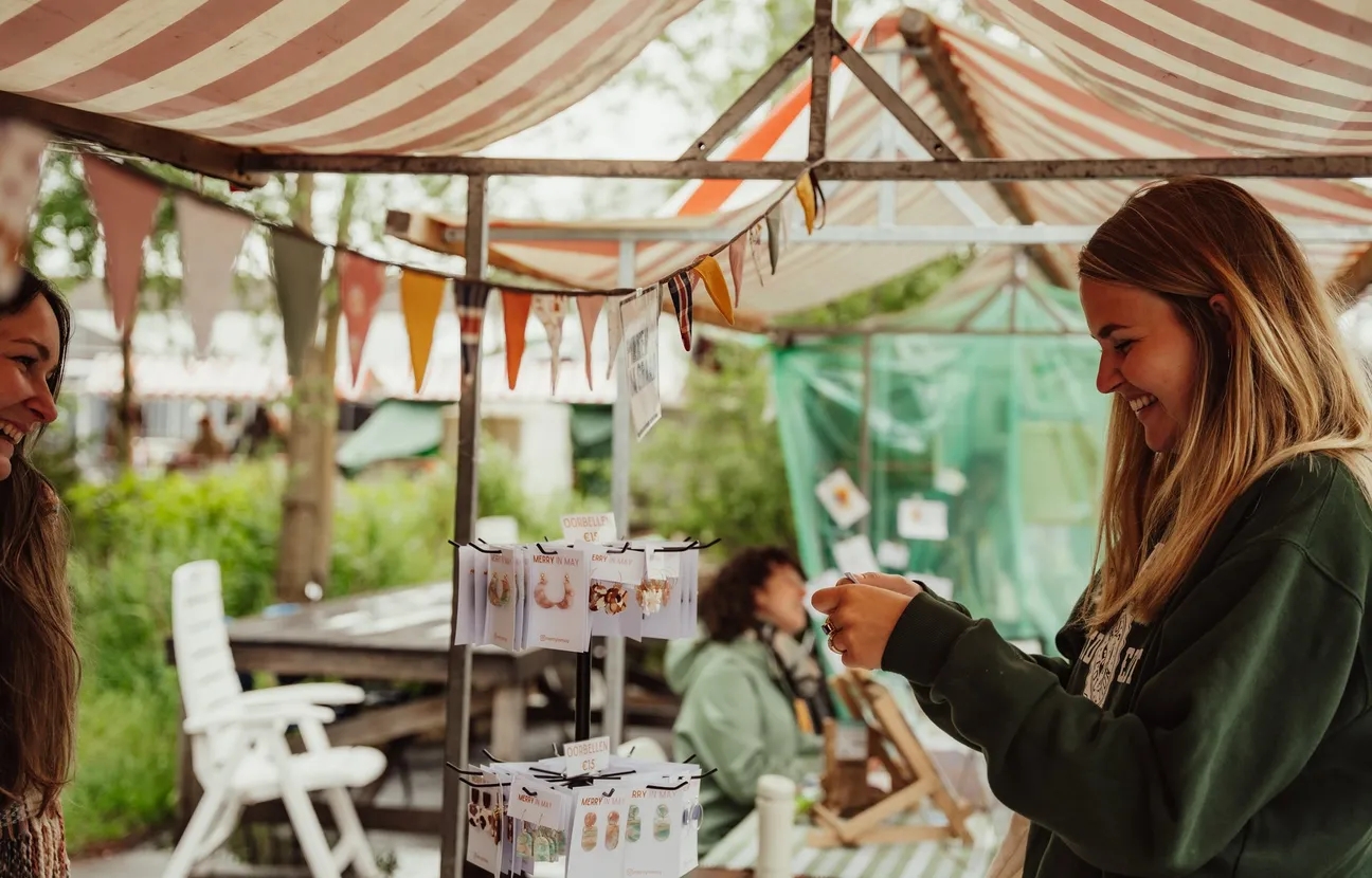 Jonge vrouw bij een kraam met sieraden