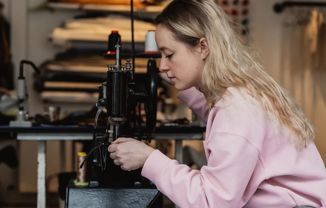 Saar in rose trui aan een naaimachine