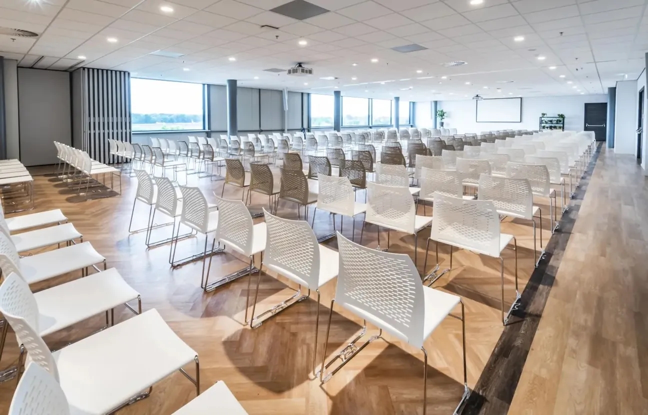 Congres zaal met veel witte stoelen bij Breepark