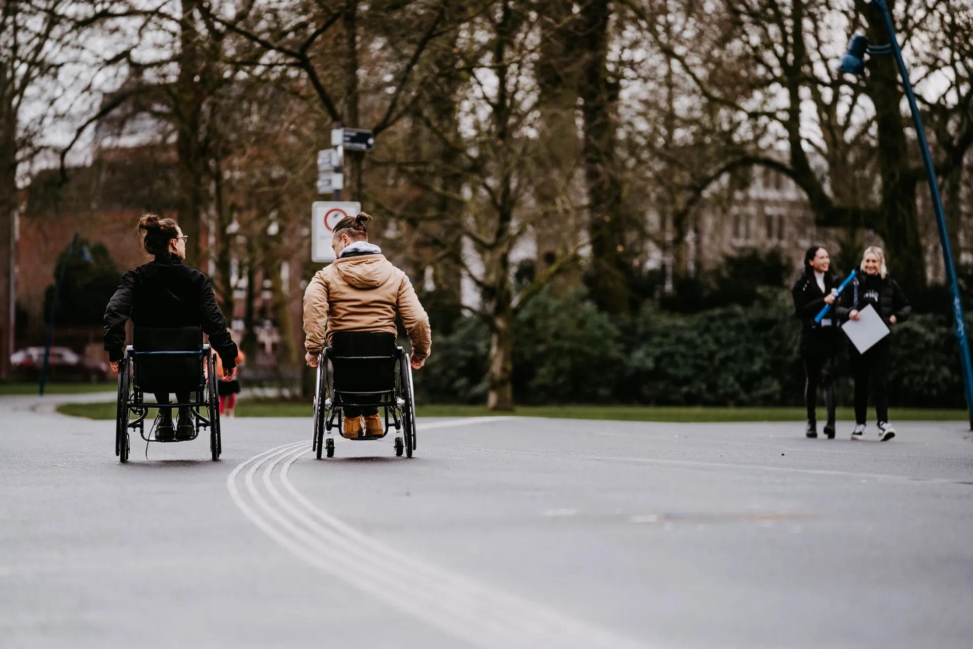 Twee mensen in een rolstoel in het Valkenberg Park in Breda
