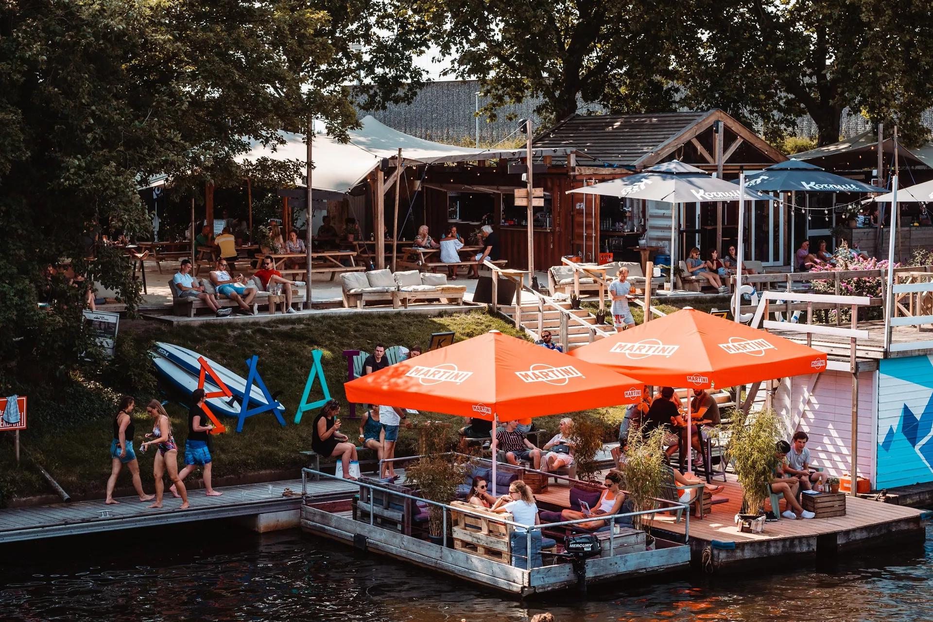 Mensen op het terras aan het water bij Baai.