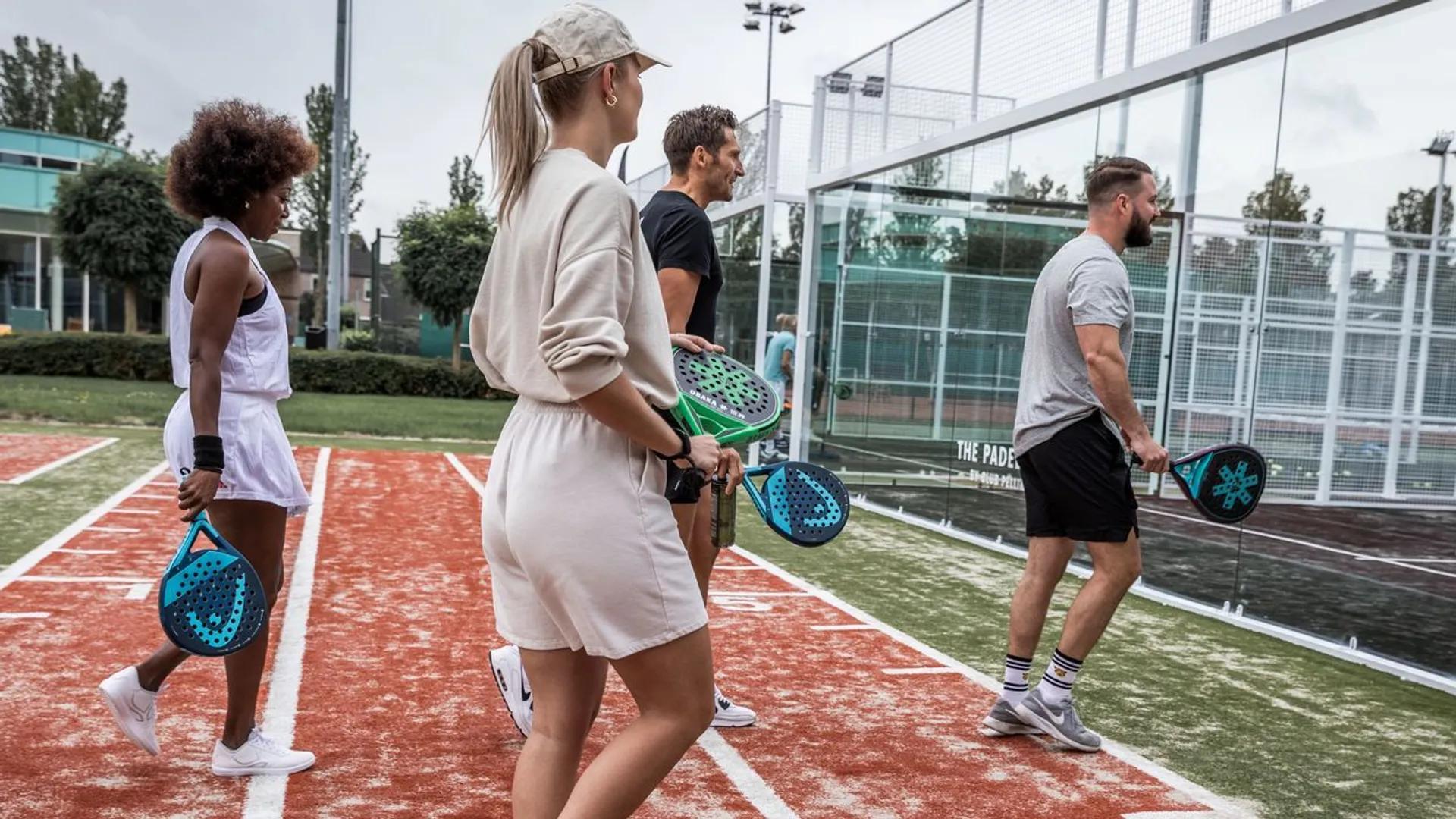 4 people holding padel rackets in the hand.